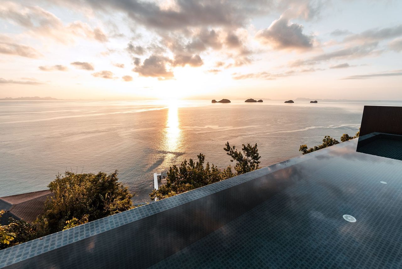 An infinity pool at sunset above the sea on Koh Samui